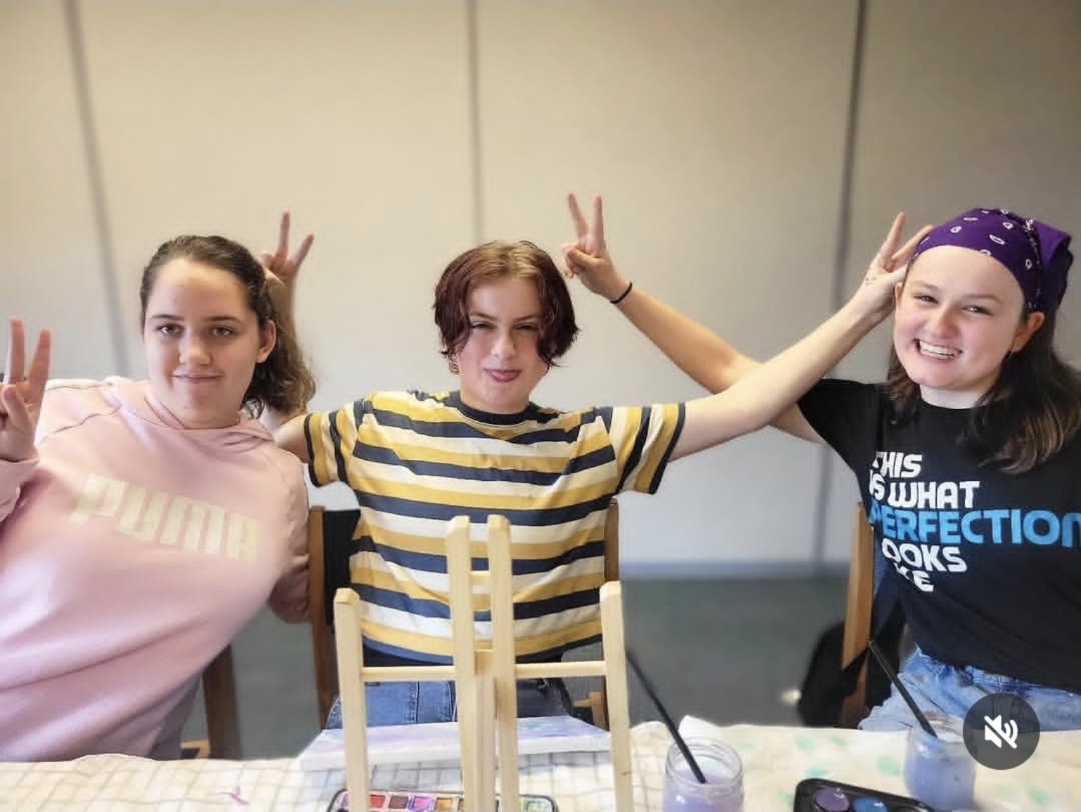 Three Buddy UP! participants smiling and posing playfully during an art activity