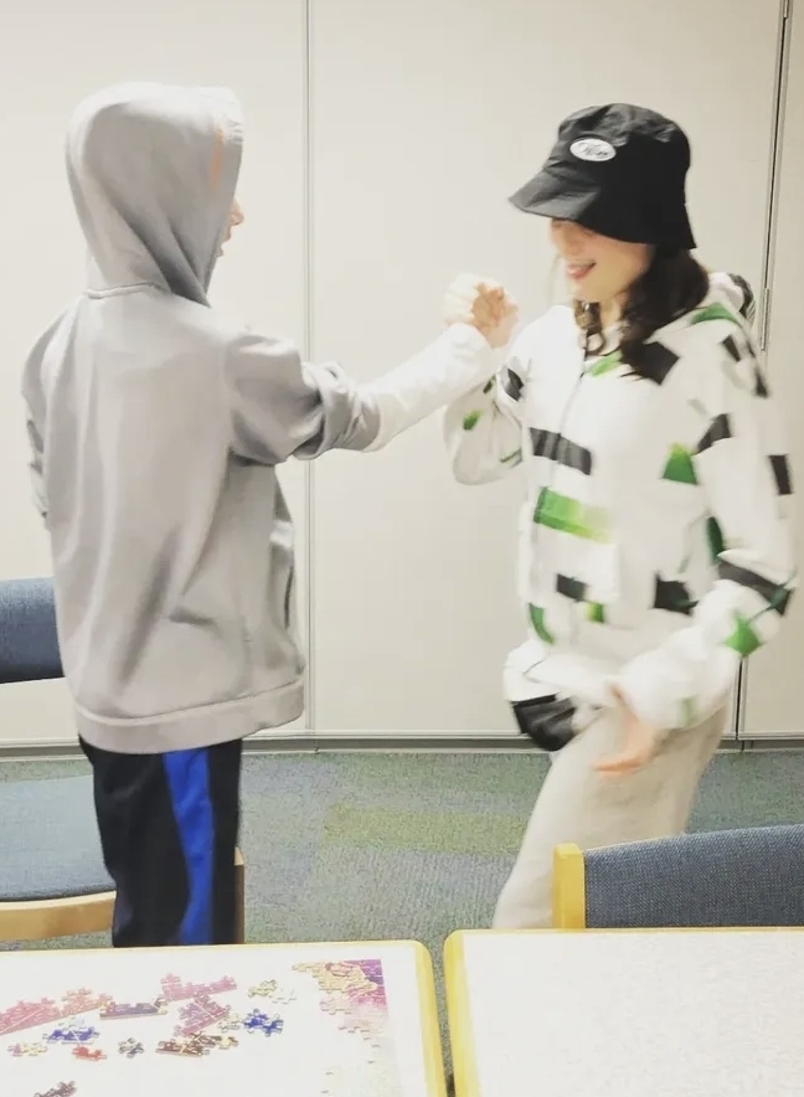 Two Buddy UP! participants laughing and sharing a friendly hand greeting