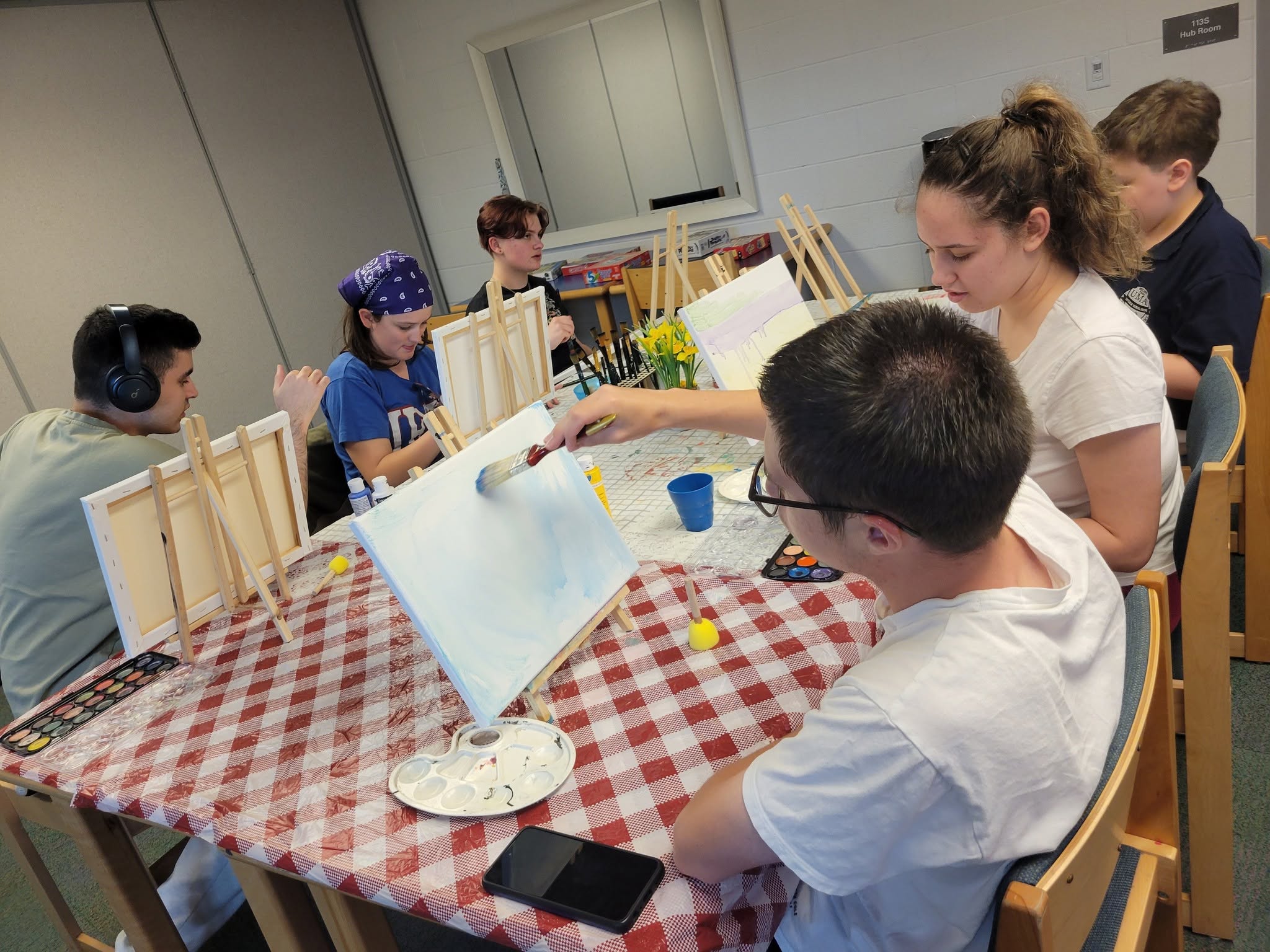 Buddy UP! participants painting together around a table at a group session